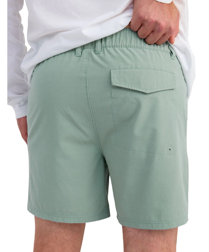 Person wearing LIGHT GREEN HUK shorts on a white background
