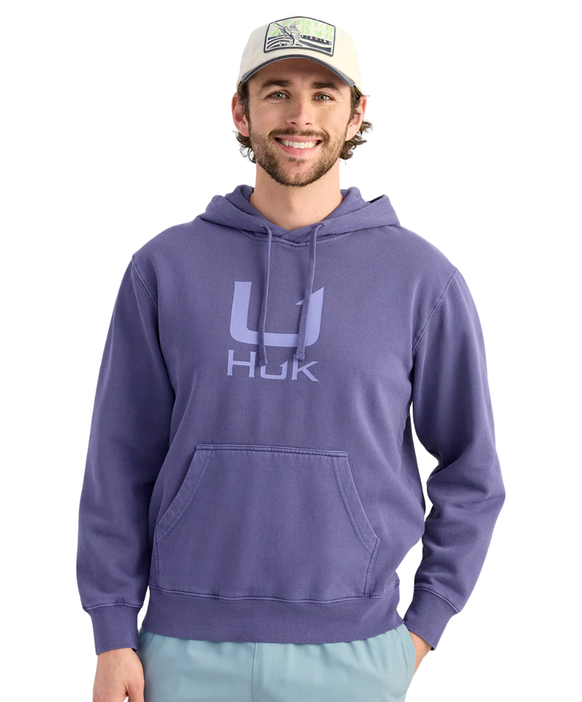 Man wearing a BLUE purple hoodie with a logo, standing against a white background