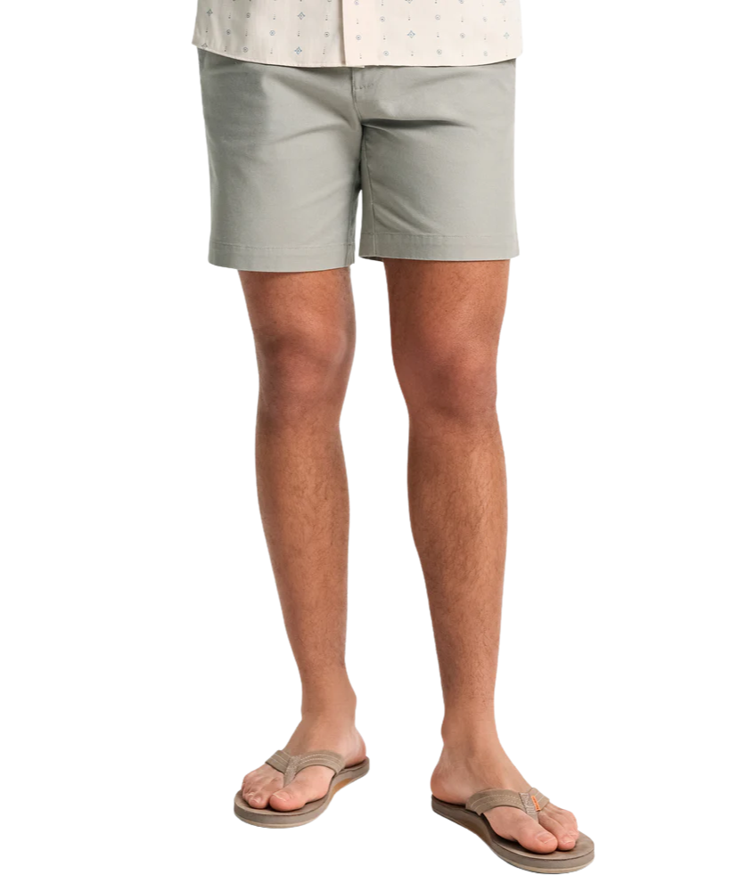 Person wearing light gray shorts on a white background