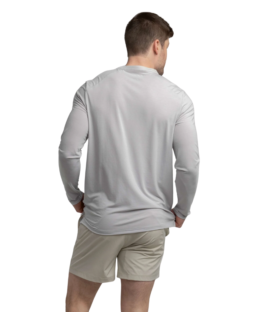 Man wearing a gray long-sleeve henley shirt and beige shorts on a white background