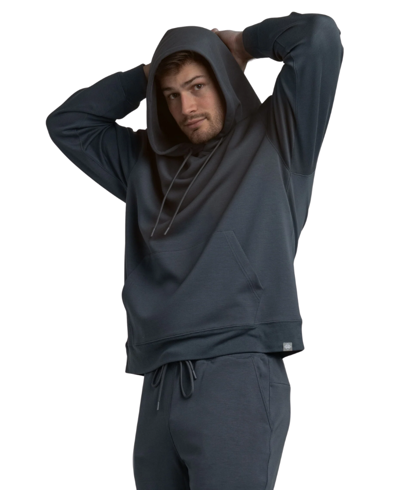Person wearing a dark blue hoodie and pants on a white background