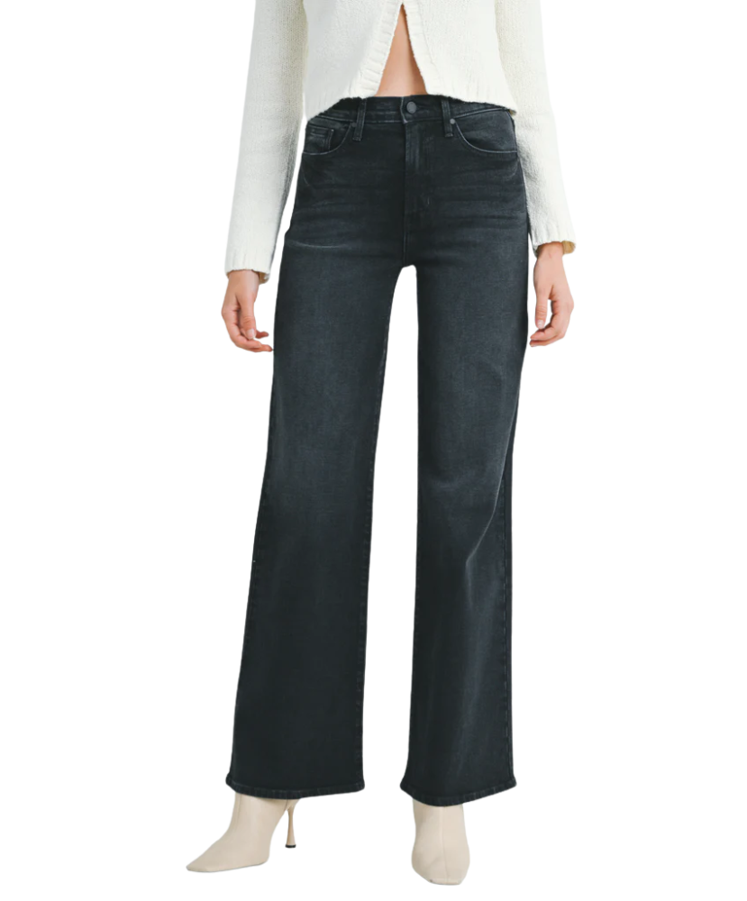 Woman wearring washed black denim pants with a high rise and wide leg
