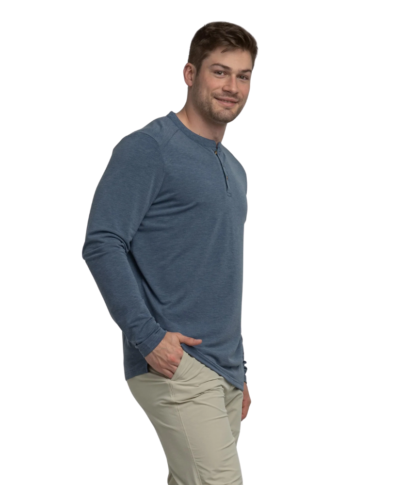 Man wearing a blue long-sleeve henley shirt and beige pants on a white background
