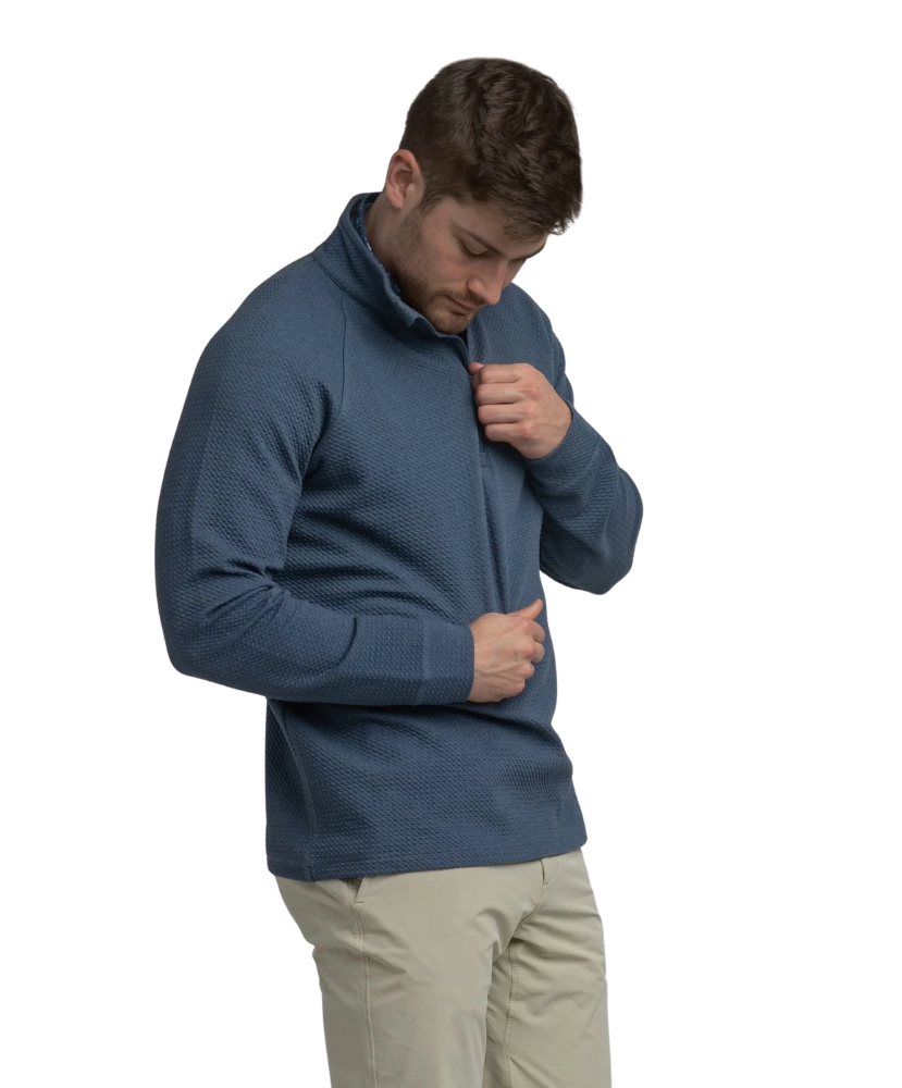Man wearing a textured blue quater-zip on a white background