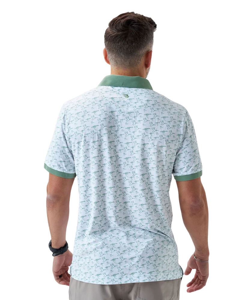 Man wearing a white duck and waterfowl patterned polo shirt with green accents on a white background