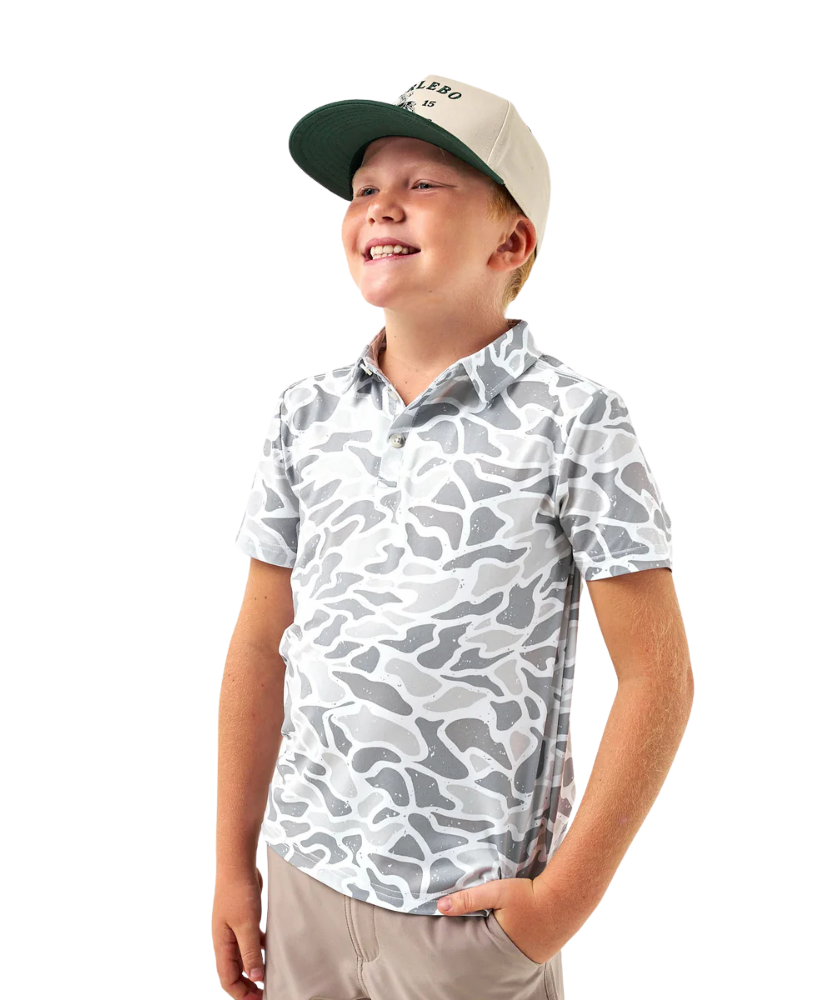 Child wearing a CAMO patterned polo shirt and cap on a white background