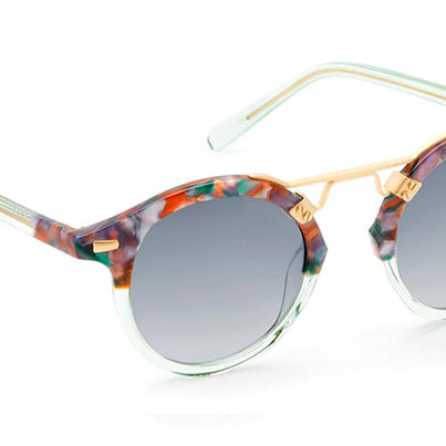 A pair of round sunglasses with pink frame and gold metal details.