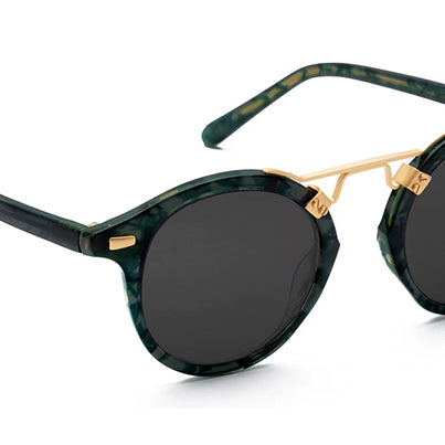 A pair of round sunglasses with pink frame and gold metal details.