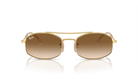 Gold-framed sunglasses with brown gradient lenses on a white background