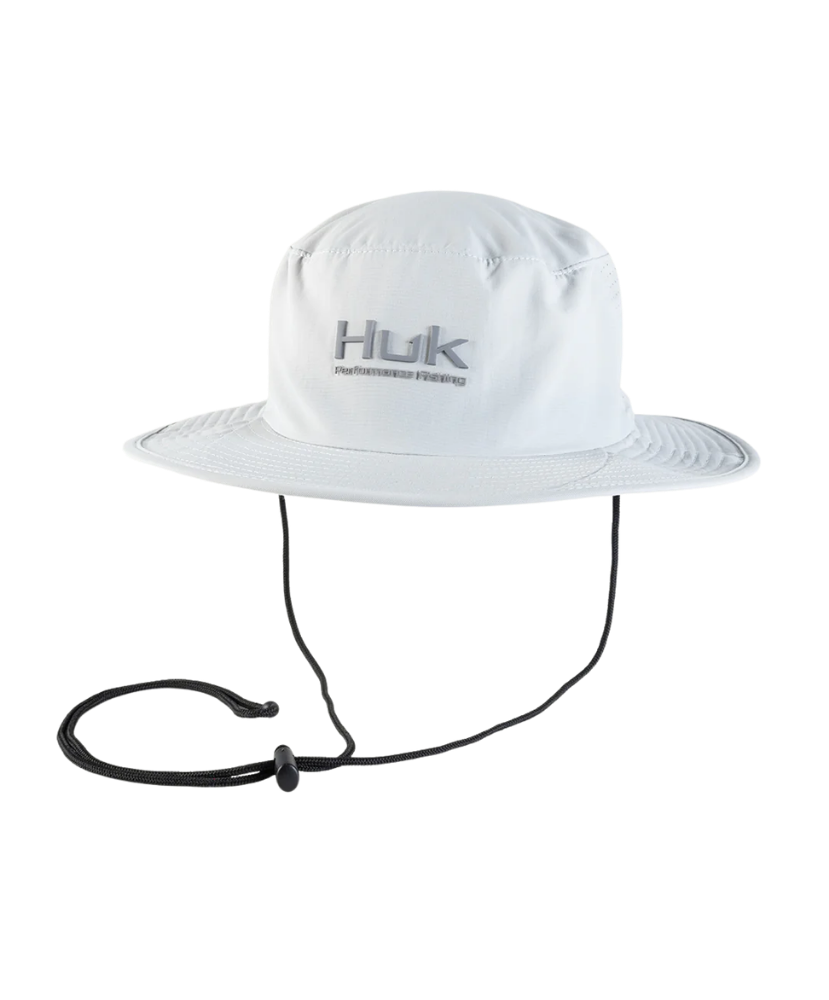 White fishing boonie hat with a strap on a white background, featuring the Huk brand.