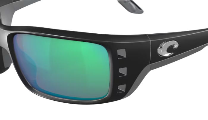 Black Costa wraparound sunglasses with green lenses on a white background