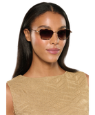 Woman wearing Krewe sunglasses with a plain background