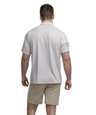 Man wearing a transfusion patterned Southern Shirt Co polo shirt and beige shorts on a white background