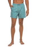 Person wearing teal patterned swim shorts on a white background