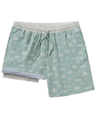 Green swim shorts with white coastal patterns on a white background
