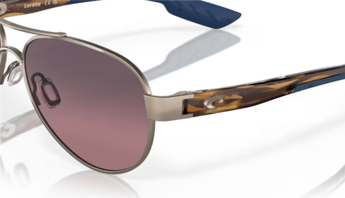 Aviator Costa sunglasses with a gradient pink lens on a white background