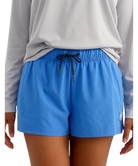 Person wearing blue shorts and a gray long-sleeve shirt on a white background