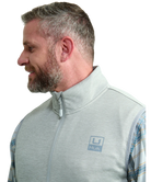 Man wearing a light gray vest WITH ZIPPER over a plaid shirt on a white background HUK GEAR