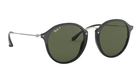 Round Ray-Ban sunglasses with black frames and green polarized lenses on a white background