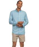 Man wearing a light blue checkered shirt and beige shorts on a white background