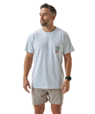 Man wearing a light gray t-shirt with a logo on a white background