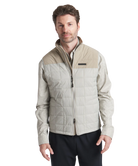 Man wearing a beige quilted jacket on a white background