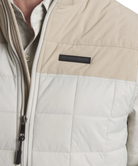 Close-up of a beige and white vest with a Southern Marsh brand logo on a light gray background