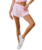 Person wearing pink shorts and white sneakers on a white background