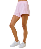 Person wearing pink shorts and white sneakers on a white background