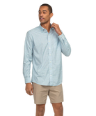 Man wearing a light blue checkered shirt and beige shorts on a white background