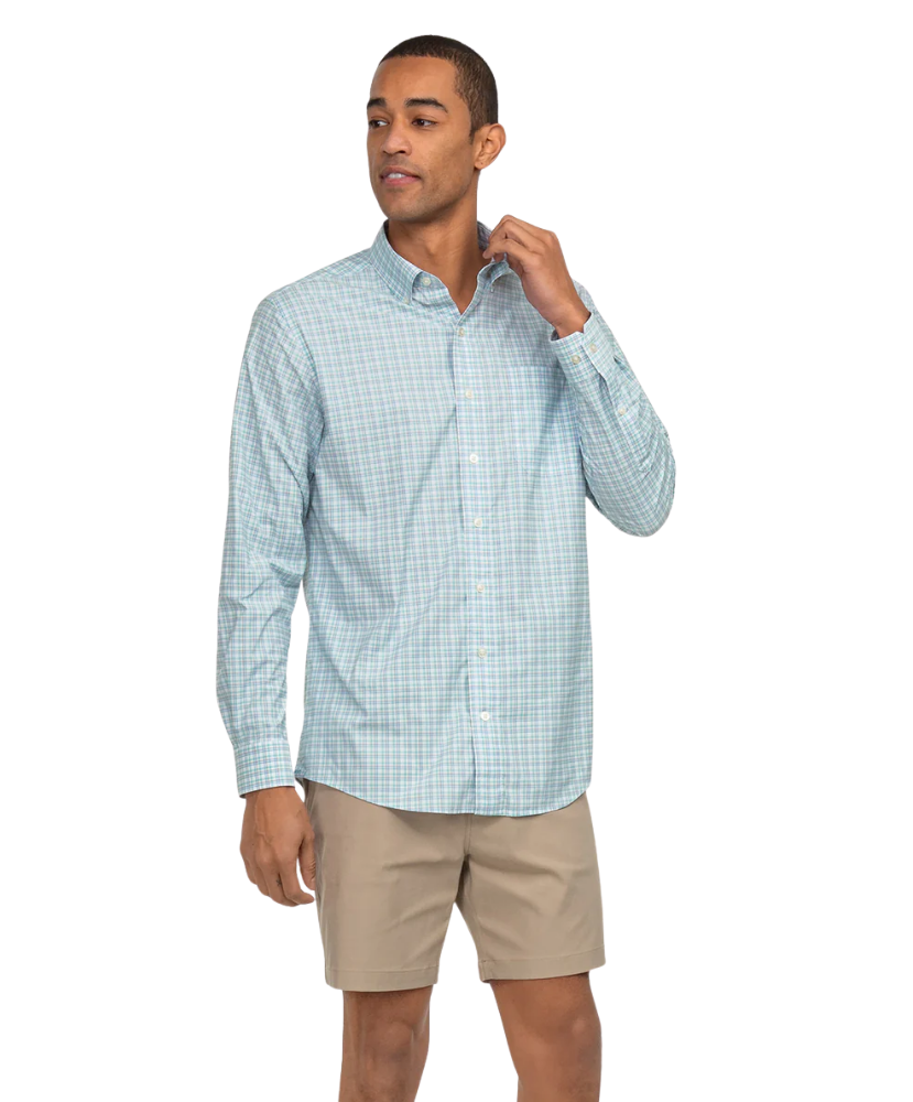 Man wearing a light blue checkered shirt and beige shorts on a white background