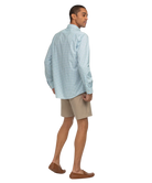 Man wearing a light blue checkered shirt and beige shorts on a white background