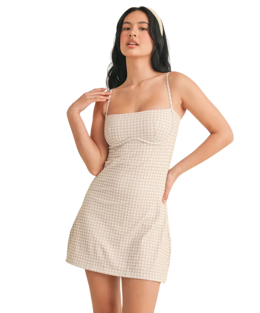 Woman wearing a beige checkered dress on a white background