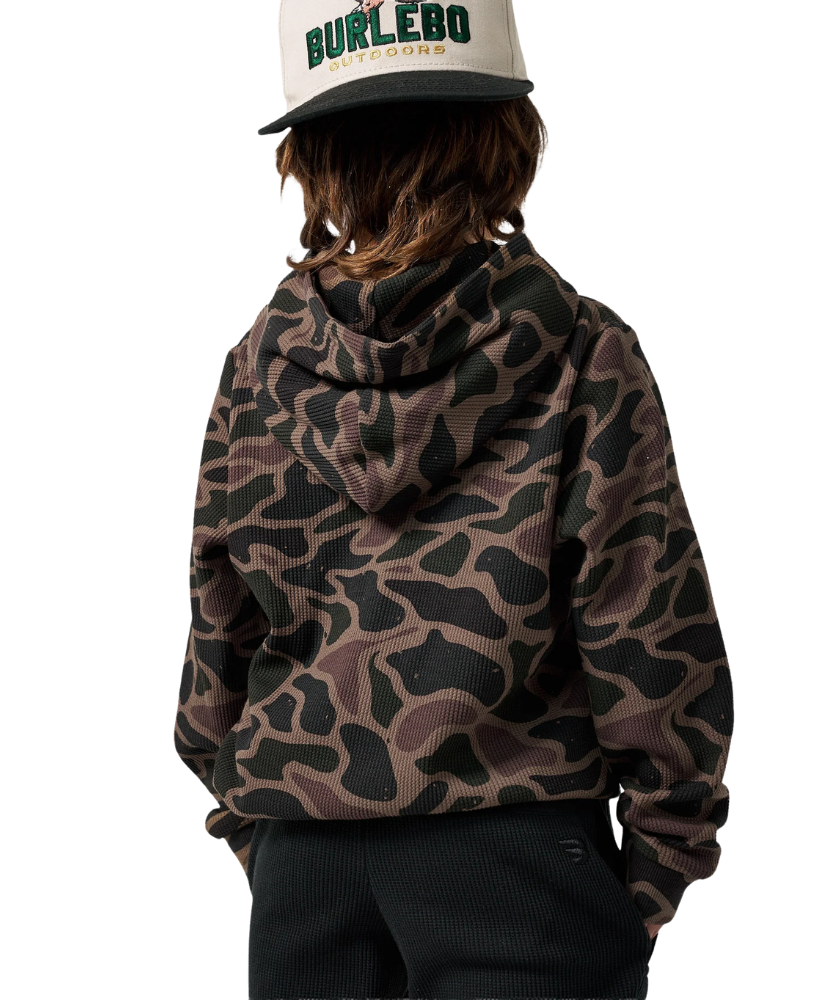 A child shown from the back wearing a brown and black camouflage hoodie, black pants, and a white cap with green and black text that reads 'BURLEBO OUTDOORS'.