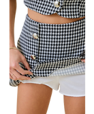 Houndstooth patterned skirt with button details on a white background