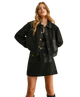 Woman wearing a black jacket and skirt set on a white background