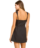 Woman wearing a black dress with thin straps on a white background