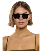 Woman wearing dark Krewe sunglasses on a white background