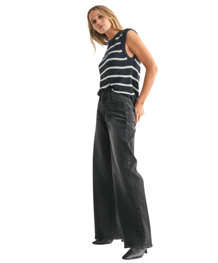 Woman wearing a striped top and black wide-leg pants on a white background