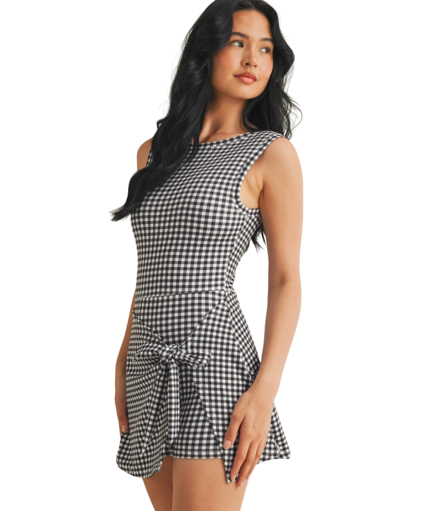 Woman wearing a black and white gingham checkered dress on a white background