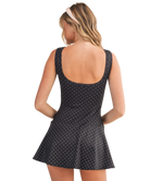 Woman wearing a black polka dot dress on a white background