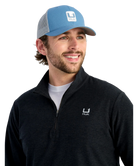 Man wearing a blue cap and black pullover with HUK logos on a white background