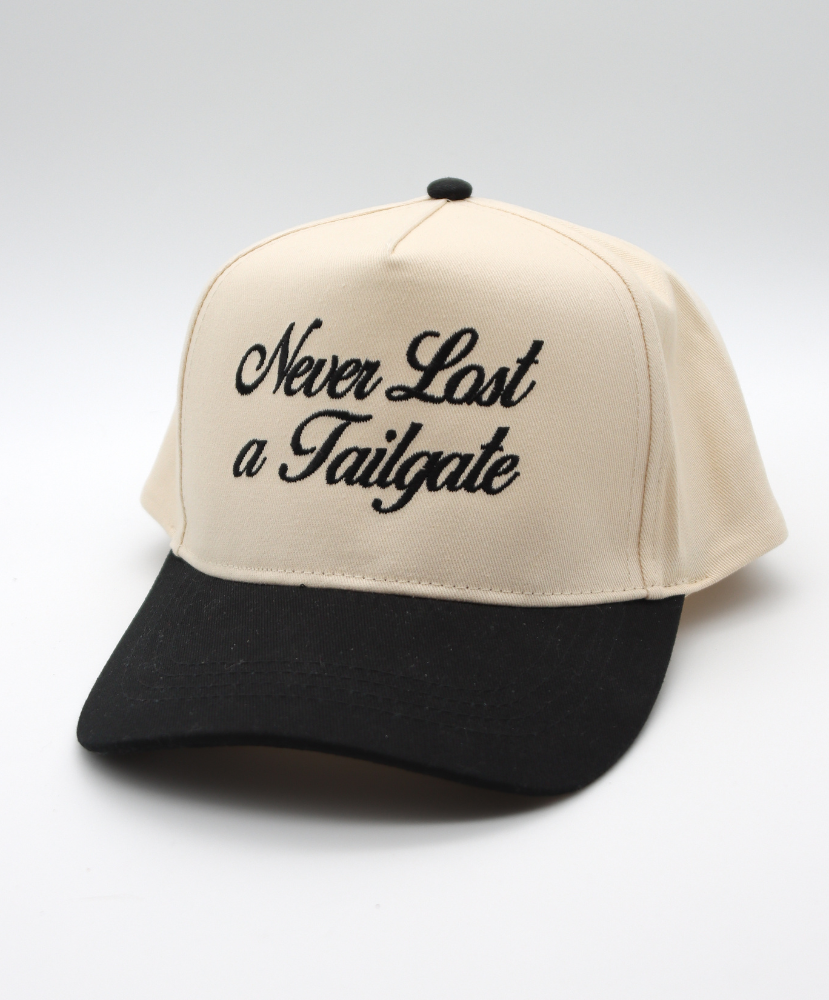 Beige and black cap with 'Never Last a Tailgate' text on a white background