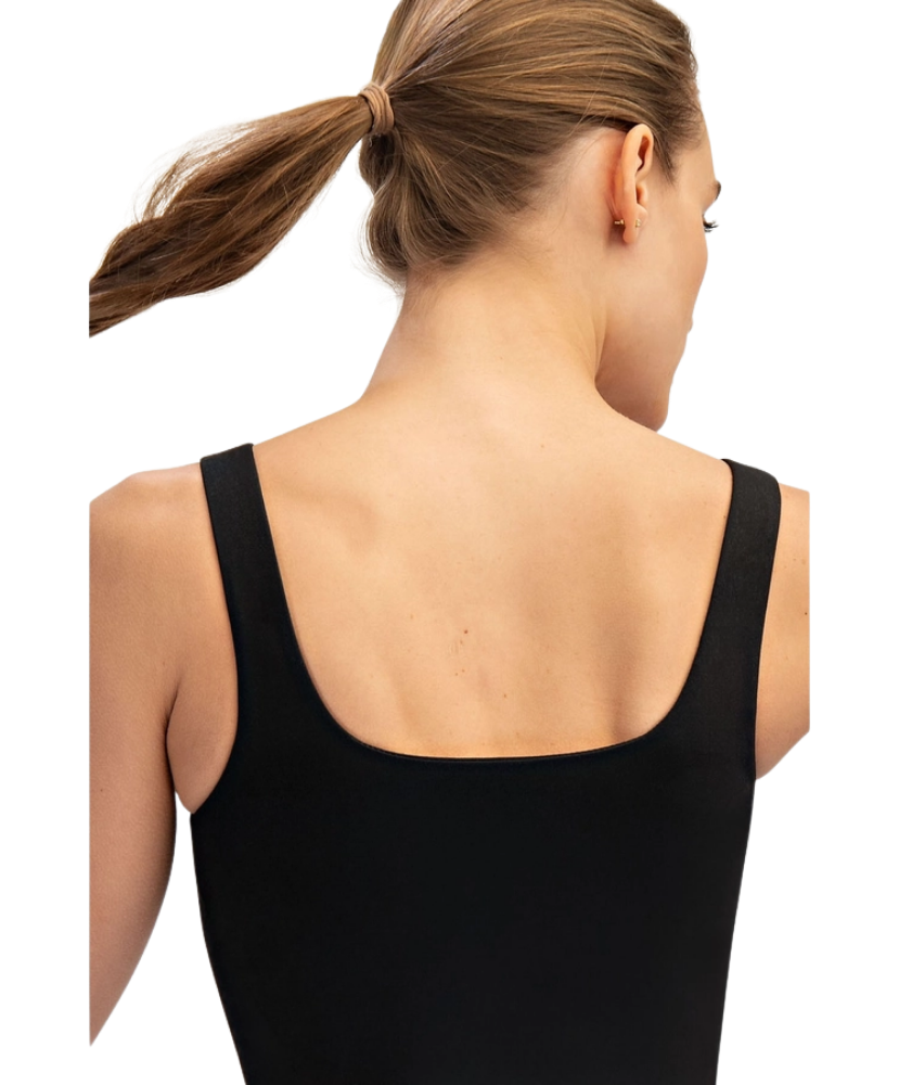 Woman wearing a black tank top with a plain white background
