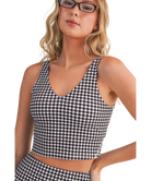 Woman wearing a black and white GINGHAM checkered tank on a white background