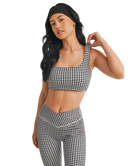Woman wearing a black and white GINGHAM checkered tsports bra on a white backgrounD