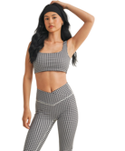 Woman wearing a black and white GINGHAM checkered tsports bra on a white backgrounD