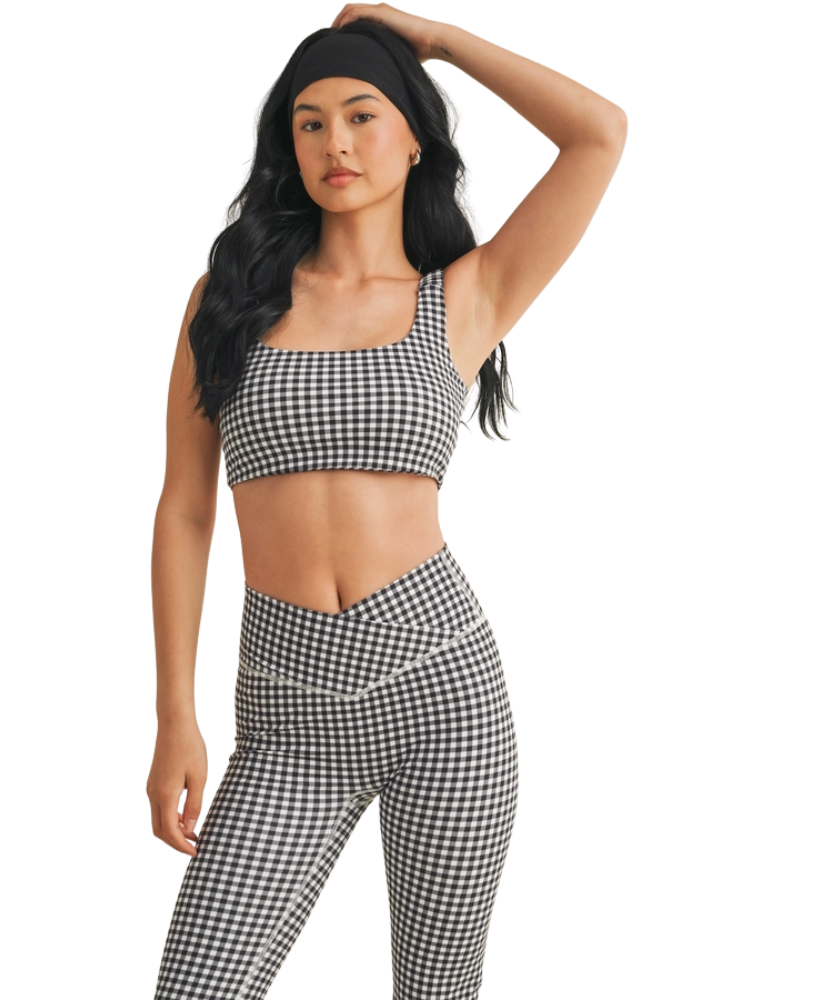Woman wearing a black and white GINGHAM checkered tsports bra on a white backgrounD