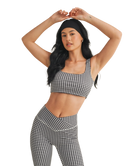 Woman wearing a black and white GINGHAM checkered tsports bra on a white backgrounD