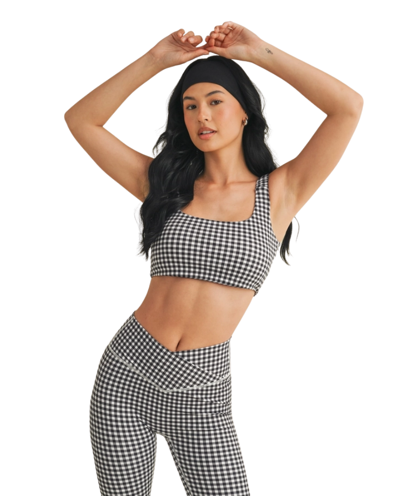 Woman wearing a black and white GINGHAM checkered tsports bra on a white backgrounD